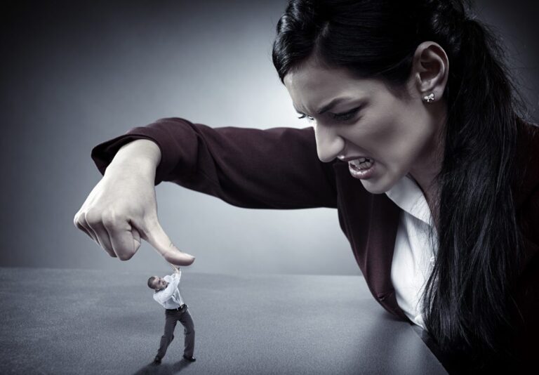 A small man in a suit struggles to push against a giant hand pressing down on him, symbolizing overwhelming pressure and power dynamics.